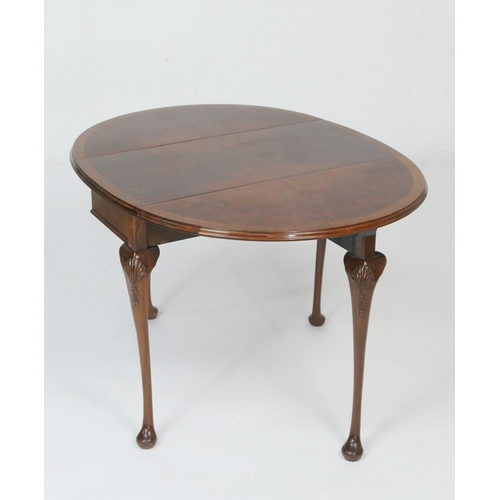 951 - Queen Anne Revival walnut drop leaf table, circa 1920-30, the crossbanded oval top with leaves, rais... 