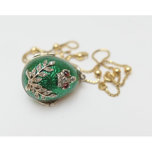 135 - CATALOGUE AMENDMENT: Description now reads An egg form pendant, with green enamelled exterior embell... 