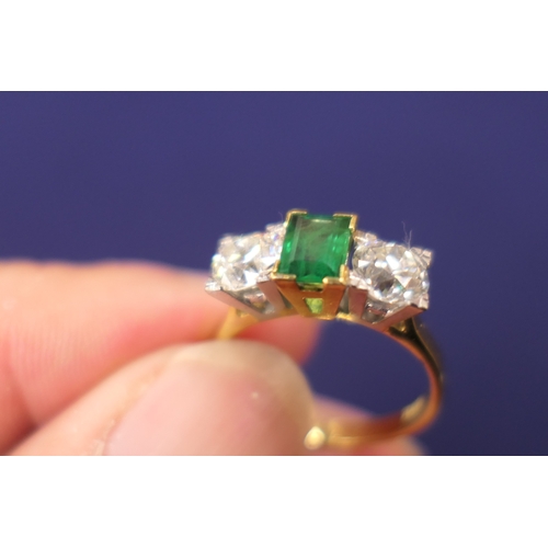 127 - Emerald and diamond three stone ring, the central emerald of approx. 0.75ct flanked by two old round... 