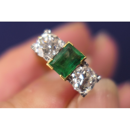 127 - Emerald and diamond three stone ring, the central emerald of approx. 0.75ct flanked by two old round... 