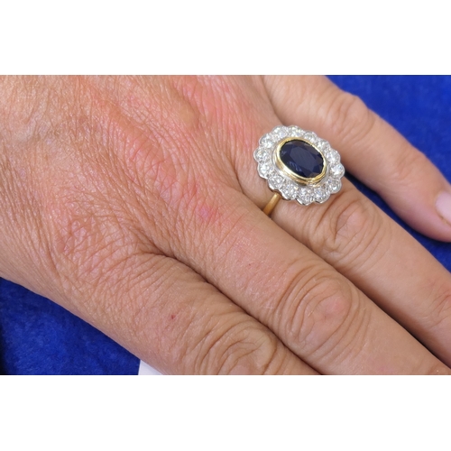 15 - Sapphire and diamond cluster ring, the oval cut sapphire approx. 9mm x 7mm, in a yellow gold collet ... 