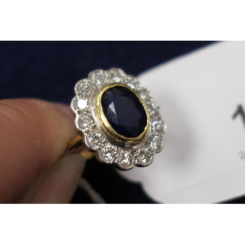 15 - Sapphire and diamond cluster ring, the oval cut sapphire approx. 9mm x 7mm, in a yellow gold collet ... 