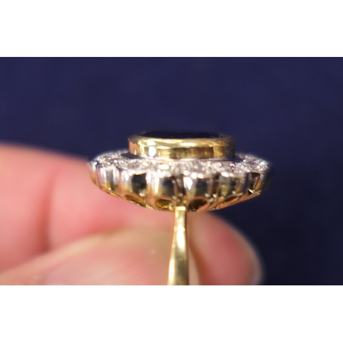 15 - Sapphire and diamond cluster ring, the oval cut sapphire approx. 9mm x 7mm, in a yellow gold collet ... 