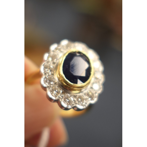 15 - Sapphire and diamond cluster ring, the oval cut sapphire approx. 9mm x 7mm, in a yellow gold collet ... 