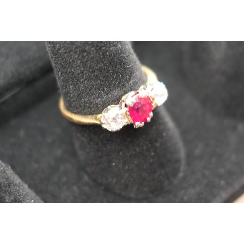 201 - Synthetic ruby and diamond three stone ring, the central cushion cut ruby of approx. 0.5ct, flanked ... 