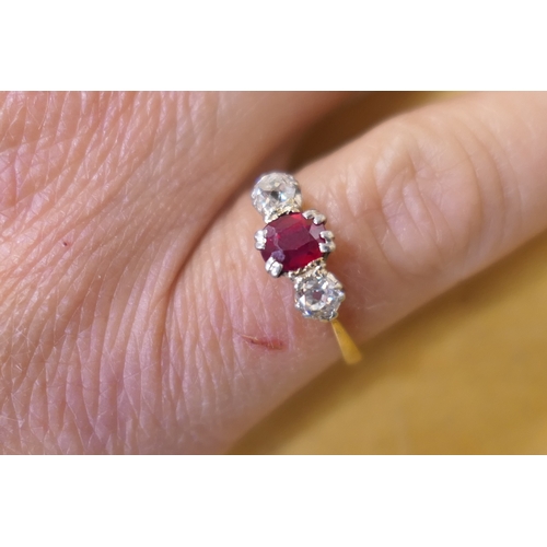 201 - Synthetic ruby and diamond three stone ring, the central cushion cut ruby of approx. 0.5ct, flanked ... 