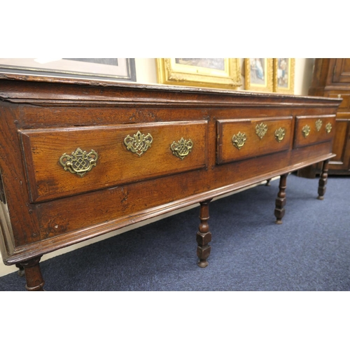 912 - Good Queen Anne oak low dresser, the top with moulded edge over three drawers with later brass fretw... 