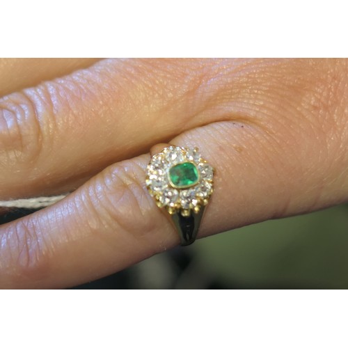 24 - Emerald and diamond cluster ring, the central emerald of approx. 0.25ct in a millegrain collet mount... 