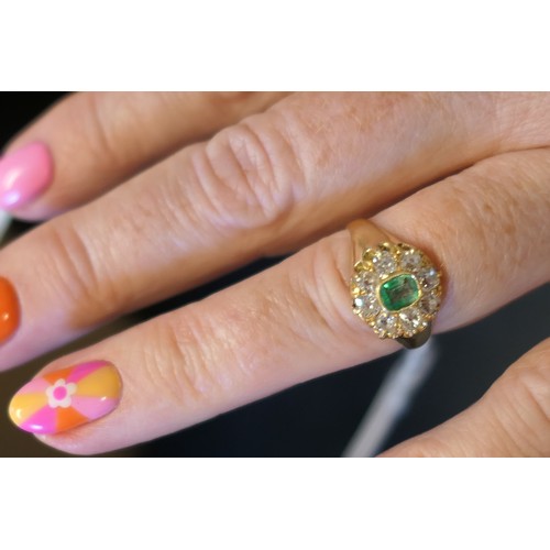 24 - Emerald and diamond cluster ring, the central emerald of approx. 0.25ct in a millegrain collet mount... 