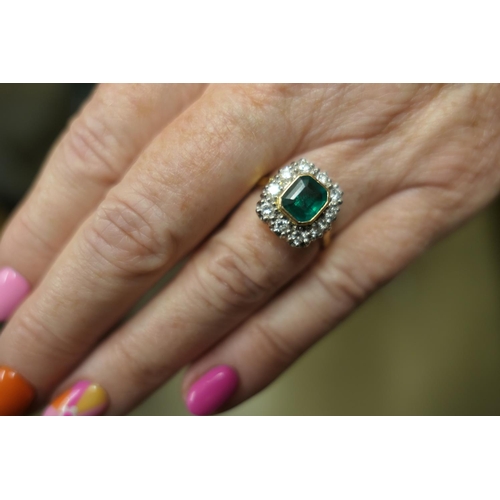 130 - Emerald and diamond cluster ring, the emerald of approx. 1ct, collet set in yellow gold and bordered... 