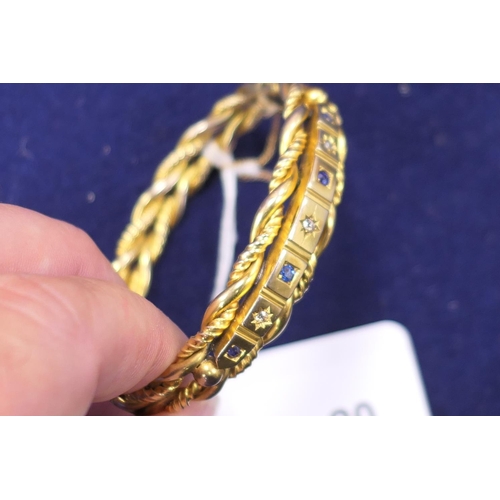 20 - Late Victorian or Edwardian diamond and sapphire set gold plated hinged bangle, formed as double twi... 