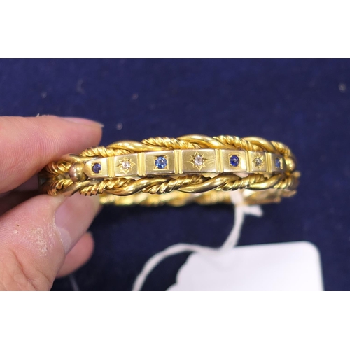 20 - Late Victorian or Edwardian diamond and sapphire set gold plated hinged bangle, formed as double twi... 