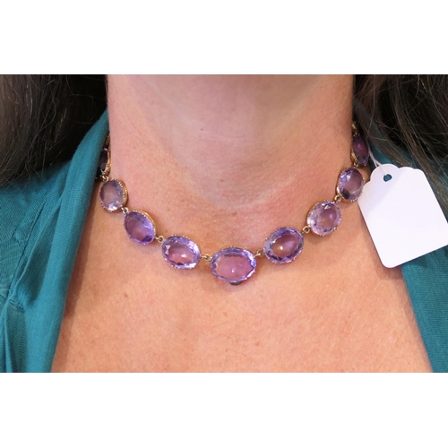 220 - Amethyst riviere necklace, circa 1900, set with 20 oval cut stones, the largest approx. 19mm x 15mm,... 