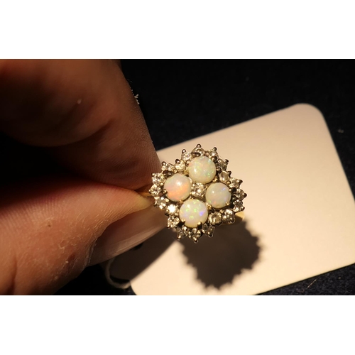 34 - Opal and diamond cluster ring, set with four cabochon round opals, centred and bordered with small b... 