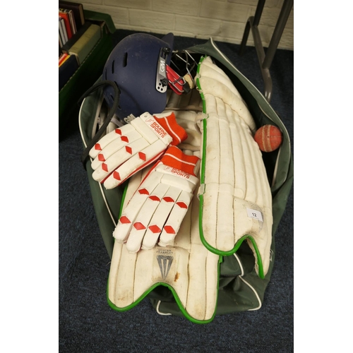 12 - Cricket pads, bats, helmet, gloves etc., all contained within a holdall