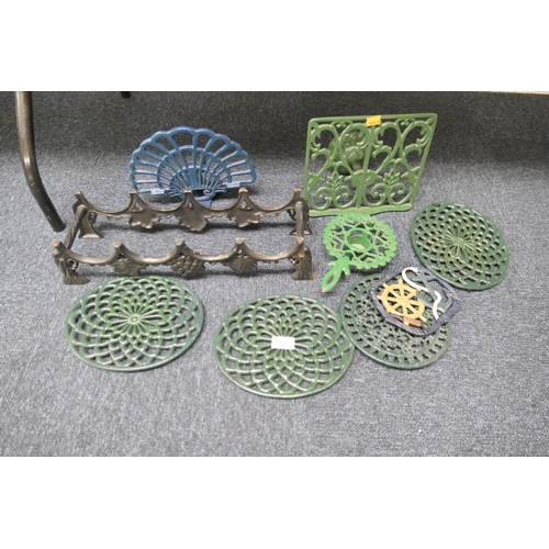 44 - Selection of modern cast iron trivets and a wine rack