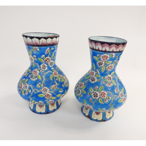 122 - Pair of Longwy blue ground prunus pattern baluster vases, height 19cm