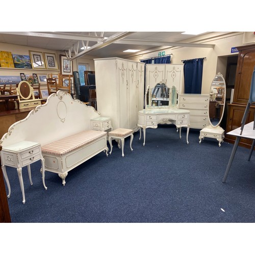 390 - Extensive French style white and parcel gilt bedroom suite comprising triple wardrobe, double wardro... 