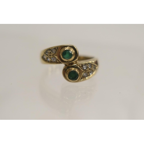 217 - Emerald and diamond crossover ring in 9ct gold, size P, gross weight approx. 4.7g