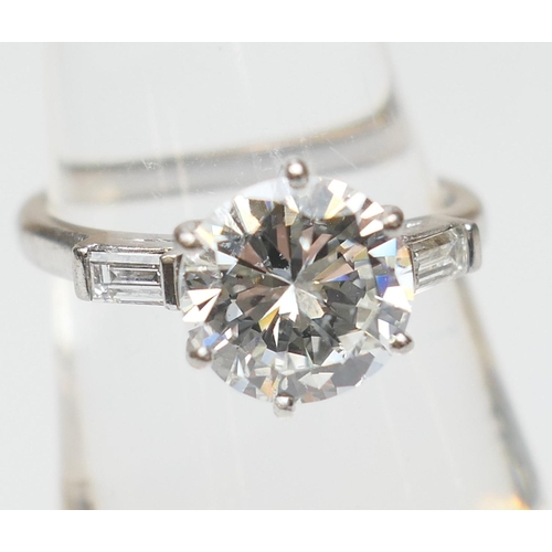 103 - Diamond three stone ring, centred with a round brilliant cut diamond of approx. 2.24cts, certificate... 