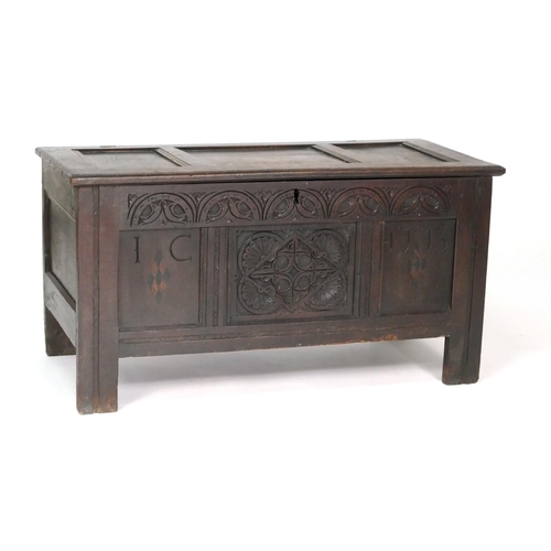 535 - Carved joined oak coffer, dated 1713, the three panel top opening to a candle box interior, with a c... 