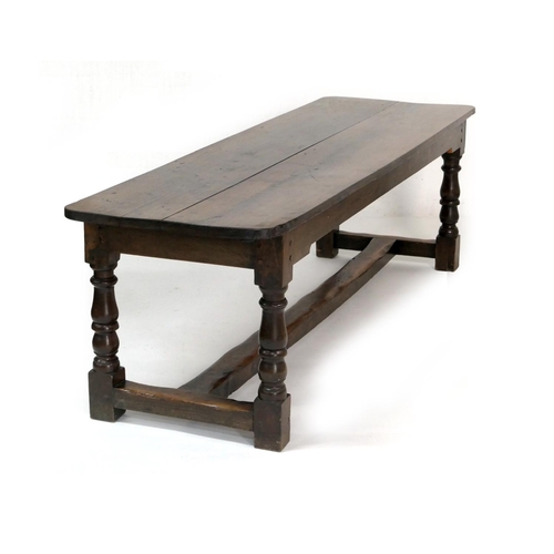 554 - Oak refectory table in 17th Century style, two plank top over turned baluster legs, united by an H-s... 