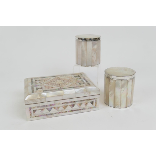 72 - Two mother of pearl and white metal mounted lidded cylinder jars, height 9cm; also a carved mother o... 