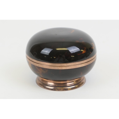 74 - Tortoiseshell bun form ring or powder box, hinged cover, mounted in gilt metal over a circular foot,... 