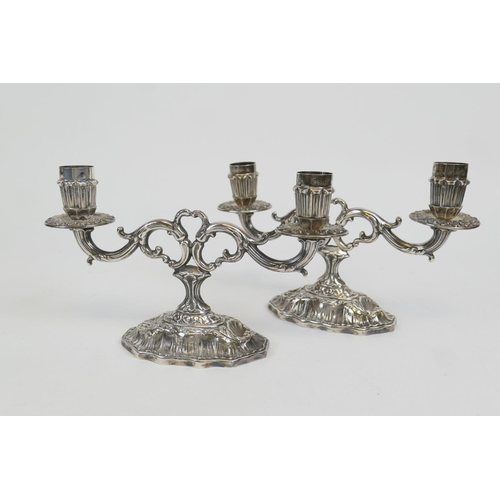 81 - Pair of Peruvian sterling silver dwarf candelabra, modern, each of twin branch form over a scalloped... 