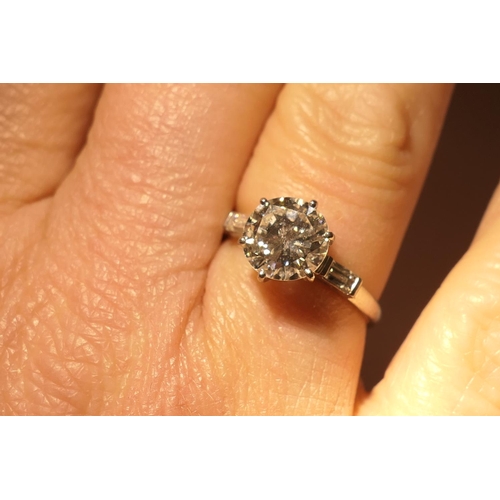 103 - Diamond three stone ring, centred with a round brilliant cut diamond of approx. 2.24cts, certificate... 