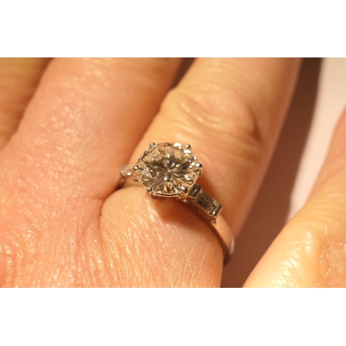 103 - Diamond three stone ring, centred with a round brilliant cut diamond of approx. 2.24cts, certificate... 