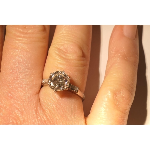 103 - Diamond three stone ring, centred with a round brilliant cut diamond of approx. 2.24cts, certificate... 