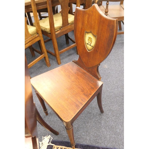 565 - Pair of George III mahogany armorial shield back hall chairs, circa 1790, the backs painted with a t... 