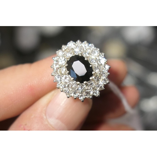 110 - Sapphire and diamond cluster ring, the oval cut sapphire approx. 9mm x 7mm, bordered with 36 round c... 