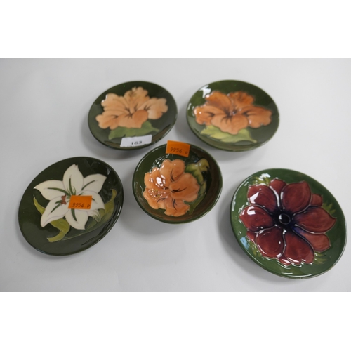 163 - Four Moorcroft green ground floral decorated pin dishes, also a green ground footed bowl (5)