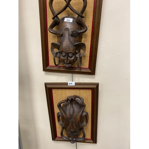 602 - Two African carved wooden wall masks, framed