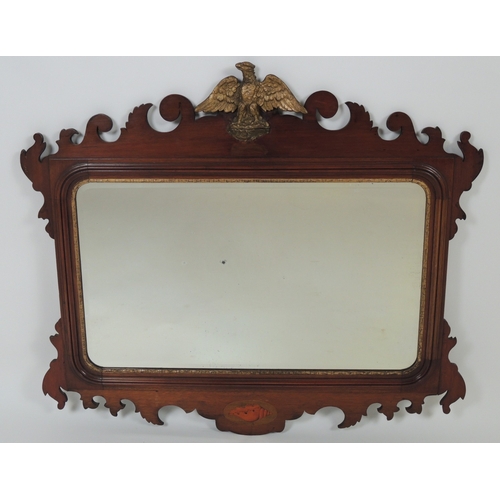 557 - Walnut and parcel gilt wall mirror in Georgian style, surmounted with a moulded gilt eagle, fretwork... 