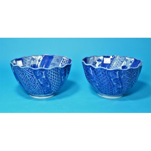 236e - A Chinese/Japanese pair of rice bowls of spiral fluted form, decorated with alternating blue & white... 
