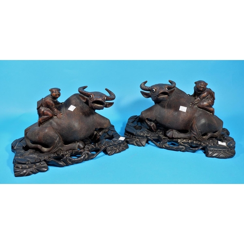 237c - A late19th/early 20th century Chinese pair of carvings, boys on buffalos, on carved hardwood bases, ... 