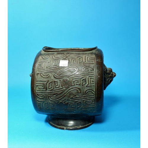239a - A 19th century Chinese bronze vase, barrel shaped with incised geometric panels, grotesque face mask... 