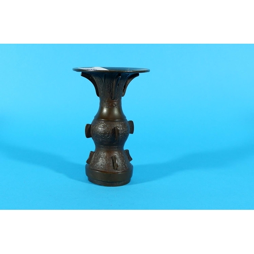 240 - A Chinese bronze vase with wide flared rim, bladed mounts and low relief decoration, height 5.5