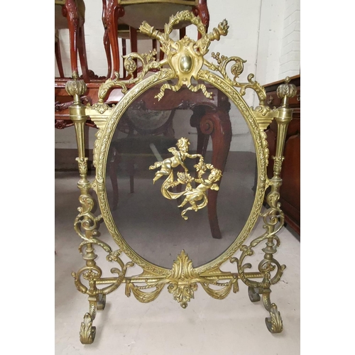 536 - An ornate gilt metal firescreen with acanthus scrolls and cherub mounts