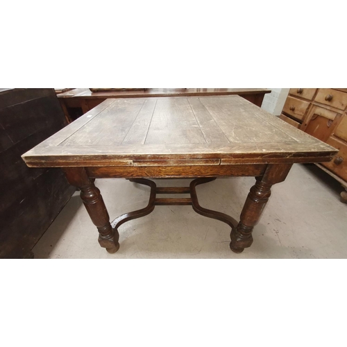 626 - A 1930's oak large draw leaf dining table on turned baluster legs and shaped stretchers