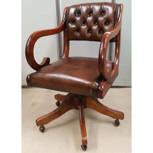 585 - A period style swivel armchair in buttoned brown hide