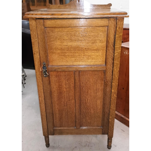 587 - An early 20th century oak side/music cabinet enclosed by panelled door