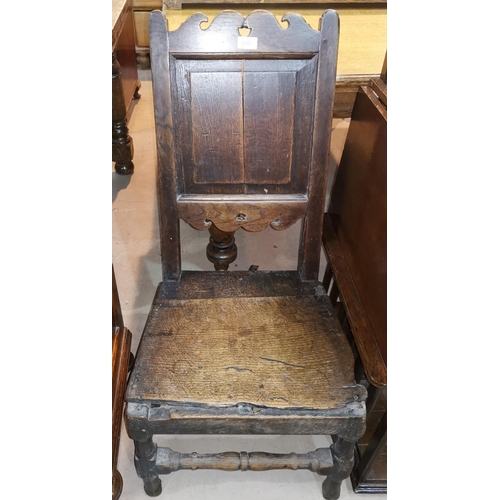 632 - A 17th century oak country made chair with panel back, arched fretted bottom and top rails, and soli... 