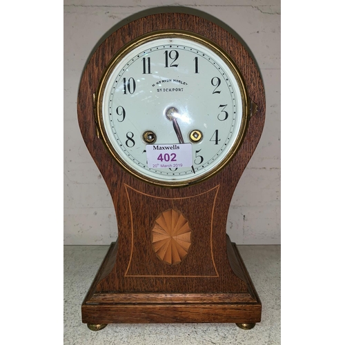 402 - An Edwardian  inlaid oak balloon top mantel clock with striking French movement, by H Kenyon, Morley... 