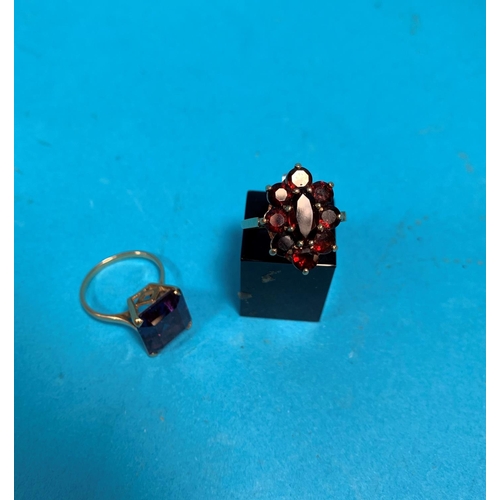 323H - A 9 carat garnet dress ring; a similar ring set with cushion cut amethysts, stamped '9ct', 8.9gm