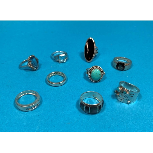 327 - A selection of 9 silver and white metal rings, set gems