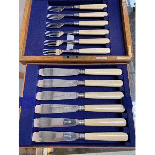 375 - A set of knives and forks with silver blades and bone handles, Sheffield 1910, in oak canteen box
